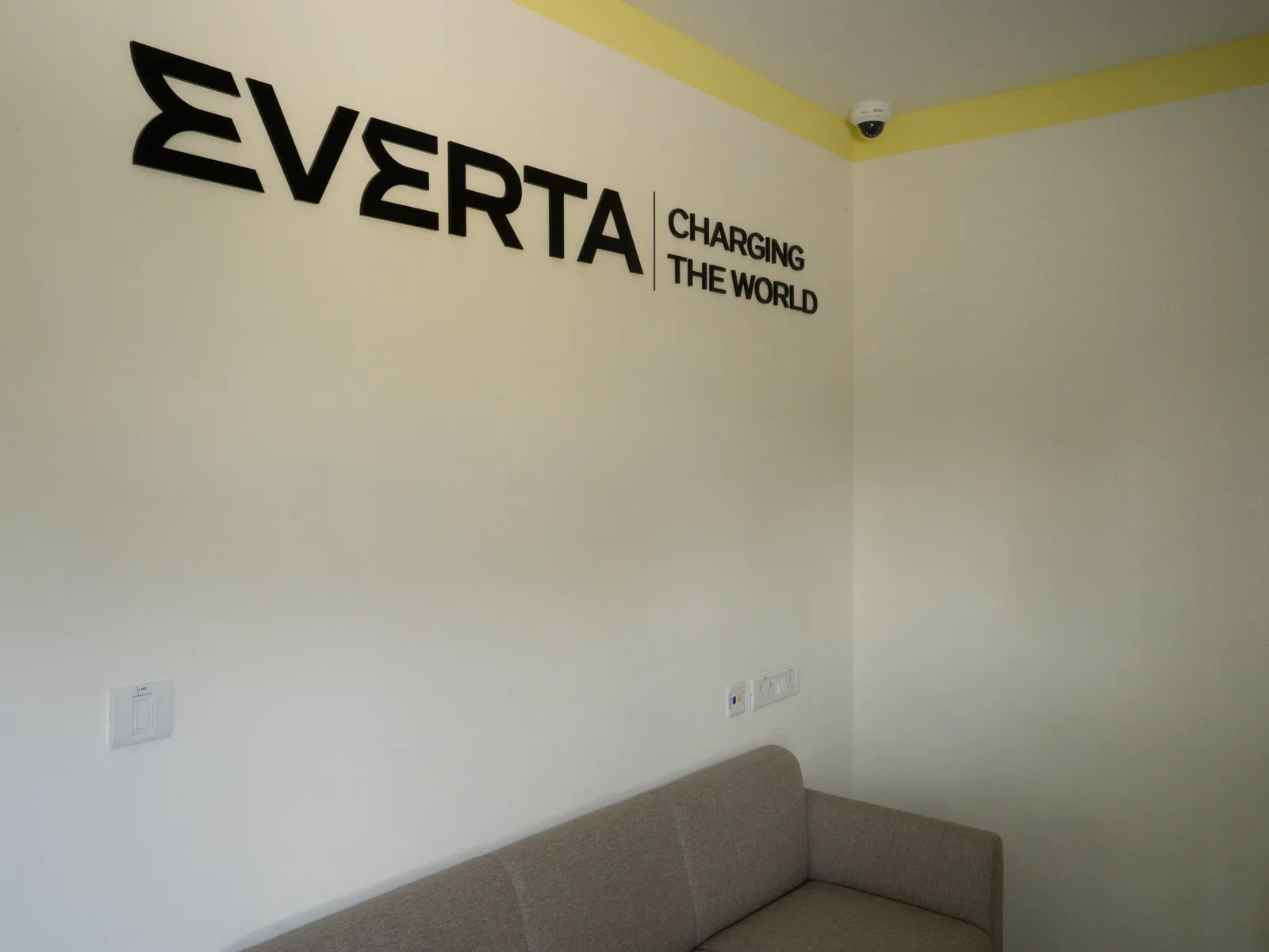 Everta reception wall with "Charging the World" branding — Everta